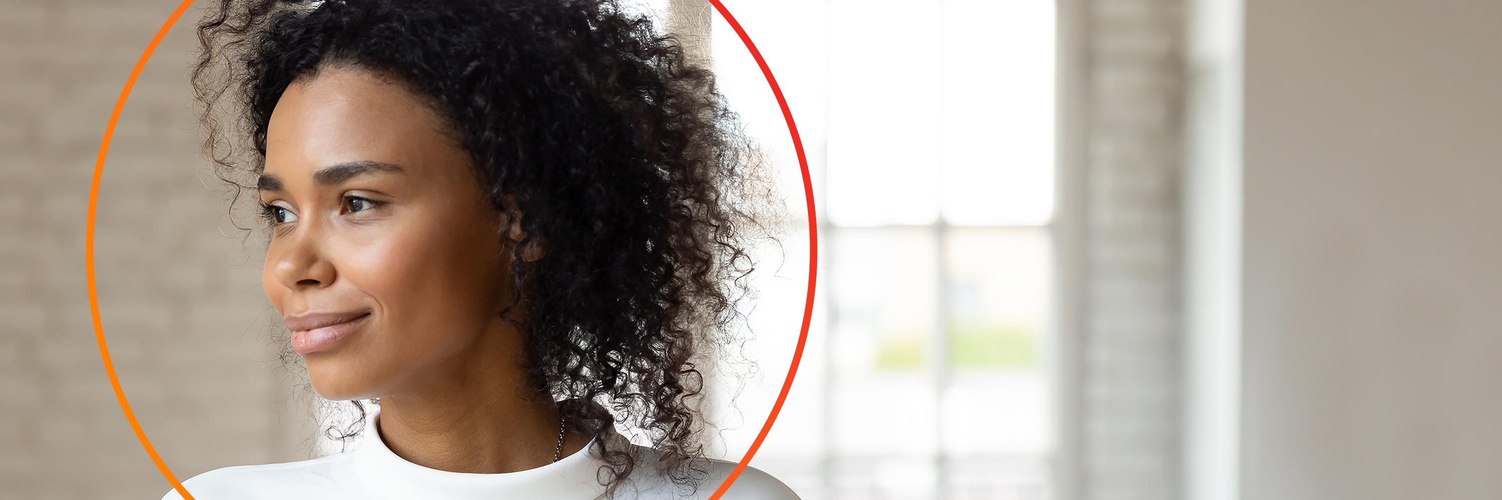 African-American woman smiling looking left with orange circle around head